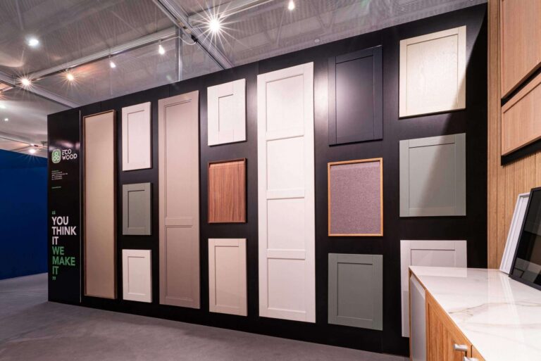 Alt text: Parete espositiva Ecowood con ante e frontali in diverse finiture e colori allo stand SICAM